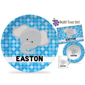 May include: A blue and white polka dot children's dinnerware set with an elephant design. The set includes a plate, bowl, and mug. The name Easton is personalized on each piece.