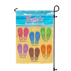 May include: A yellow garden flag with the text "Nana's Favorite Beach" and a beach scene with flip flops in various colors. Each pair of flip flops has a name written below them: Aubrey, Riley, Joseph, Amelia, Evan, and Maddie.