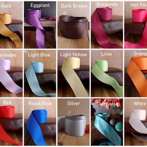 May include: A collection of 24 satin ribbon spools in various colors, including black, gold, eggplant, dark brown, burgundy, hot pink, hunter green, ivory, lavender, light blue, light yellow, lime, orange, pink, purple, red, royal blue, silver, turquoise, white, and yellow.