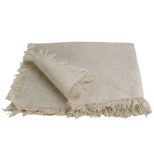 May include: A beige linen napkin with frayed edges. The napkin is folded in half and the edges are visible.