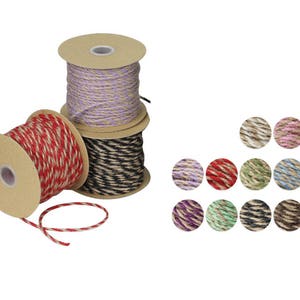 May include: Three spools of twine, each with a different color combination. The spools are made of cardboard and have a natural brown color. The twine is made of natural fibers and is available in a variety of colors, including red, black, and purple.