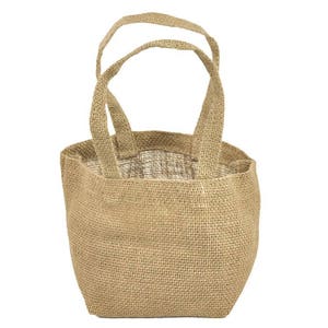 Pu&ograve; includere: Una piccola borsa di juta marrone con due manici. La borsa &egrave; realizzata in tessuto di juta naturale e ha un design semplice e rustico.