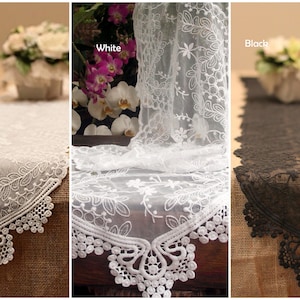 May include: Three lace table runners in ivory, white, and black. Each runner has a delicate floral pattern and a scalloped edge.