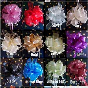 May include: A collection of 16 different colored sheer ribbon bows. The bows are arranged in a grid pattern on a black background with white polka dots. The colors include white, lavender, pink, peach, hot pink, red, silver, ivory, cream, gold, yellow, purple, black, royal blue, lime green, burgundy, orange, light blue, and brown.