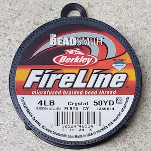 May include: A circular spool of FireLine microfused braided bead thread. The label features the text "FireLine" in large, bold letters, with "Berkley" and "The Beadsmith" branding. The spool contains 50 yards of 4LB crystal thread.