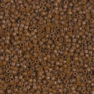 May include: Close-up of a pile of small, cylindrical brown beads. Each bead has a hole running through the center. The beads are a solid, matte brown color and appear to be made of plastic or a similar material. The beads are scattered randomly.