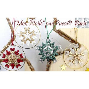 May include: Four beaded snowflake ornaments in gold, white, red, and green hanging from gold hoops. The ornaments are labeled "Mon Etoile" by Pucca-Paris.