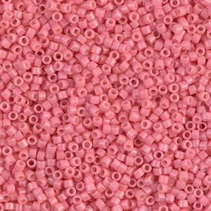 May include: A close-up shot of a pile of small, cylindrical, light pink beads. The beads are uniform in size and shape, with a hole running through the center of each. These beads are ideal for jewelry making and crafting.