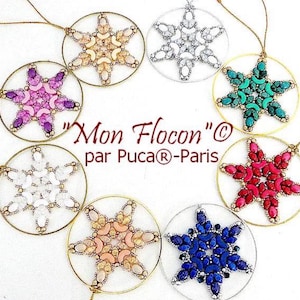 May include: A collection of eight snowflake-shaped pendants. Each pendant features a beaded snowflake design in various colors, including pink, blue, green, and white, set within a gold or silver circular frame. The text "Mon Flocon" is visible.
