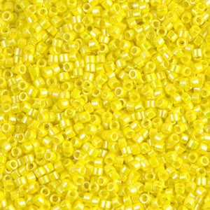 May include: Close-up of a pile of small, cylindrical yellow beads. Each bead has a hole running through the center. The beads are a bright, sunny yellow color, and the light reflects off their surfaces. These beads are suitable for jewelry making and crafts.