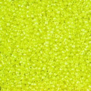 May include: Close-up of a pile of small, translucent, chartreuse-colored seed beads. The beads are cylindrical with a hole running through the center, and they are densely packed together, creating a textured surface.