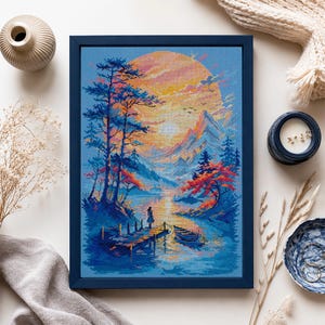 May include: A framed cross-stitch embroidery depicting a landscape with a large yellow sun setting behind mountains, tall pine trees, and a person standing on a wooden dock next to a small boat on a blue lake, rendered in vibrant pixelated colors.