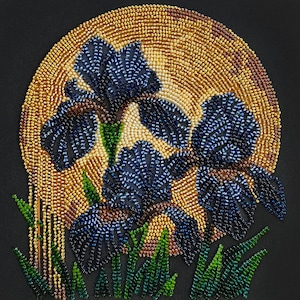 May include: A beaded artwork depicting blue iris flowers with green stems and leaves, set against a golden, sun-like backdrop. The piece is on a black background, highlighting the detailed beadwork.