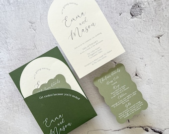 May include: A green and white wedding invitation with a pocket for a smaller card. The invitation features a whimsical arch design with the text "we're getting married" and the names "Emma and Mason". The smaller card has the text "The finer details" and includes information about the wedding, such as the date, time, and location.