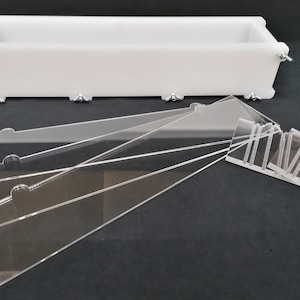 Puede incluir: Un molde de jab&oacute;n de pl&aacute;stico blanco con forma rectangular y clips met&aacute;licos. El molde viene acompa&ntilde;ado de varios divisores de acr&iacute;lico transparente para crear barras de jab&oacute;n con diferentes dise&ntilde;os.