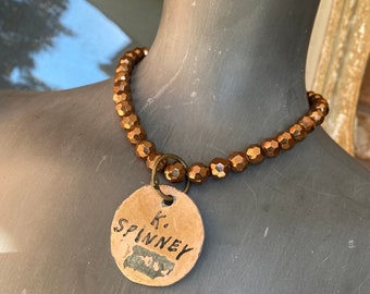 Vintage gold beaded necklace with vintage metal tag