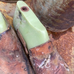 May include: Two brown leather shoe forms with a green plastic insert. The forms are worn and have a distressed look.