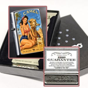May include: A silver Zippo lighter with a vintage Camel cigarettes graphic featuring a woman, a camel, and pyramids. The lighter is in a black box with a guarantee card and a metal base with "Zippo" and "Made in USA" text.