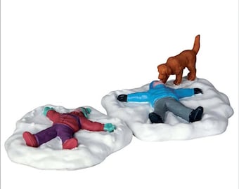 May include: Two children making snow angels in the snow. A brown dog is sniffing one of the snow angels.
