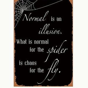 May include: Black rectangular sign with white text and a spider web graphic. The text reads "Normal is an illusion. What is normal for the spider is chaos for the fly."