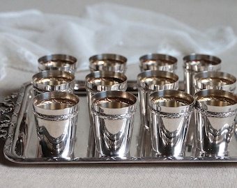 Juego de 12 vasos de licor antiguos franceses bañados en plata con bandeja para servir. Ideales para después de la cena. Con motivos Luis XVI y lazos.