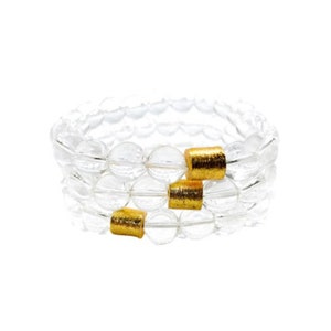 May include: A triple-strand bracelet made of clear glass beads with gold accents.