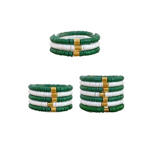 May include: Three green and white beaded bracelets with gold spacers. The bracelets are stacked on top of each other.