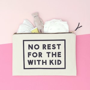 Puede incluir: Una bolsa de lona blanca con cremallera con el texto "NO REST FOR THE WITH KID" impreso en negro. La bolsa est&aacute; llena de art&iacute;culos para beb&eacute;s, incluyendo un pa&ntilde;al, un peque&ntilde;o animal de peluche y un tubo de loci&oacute;n.
