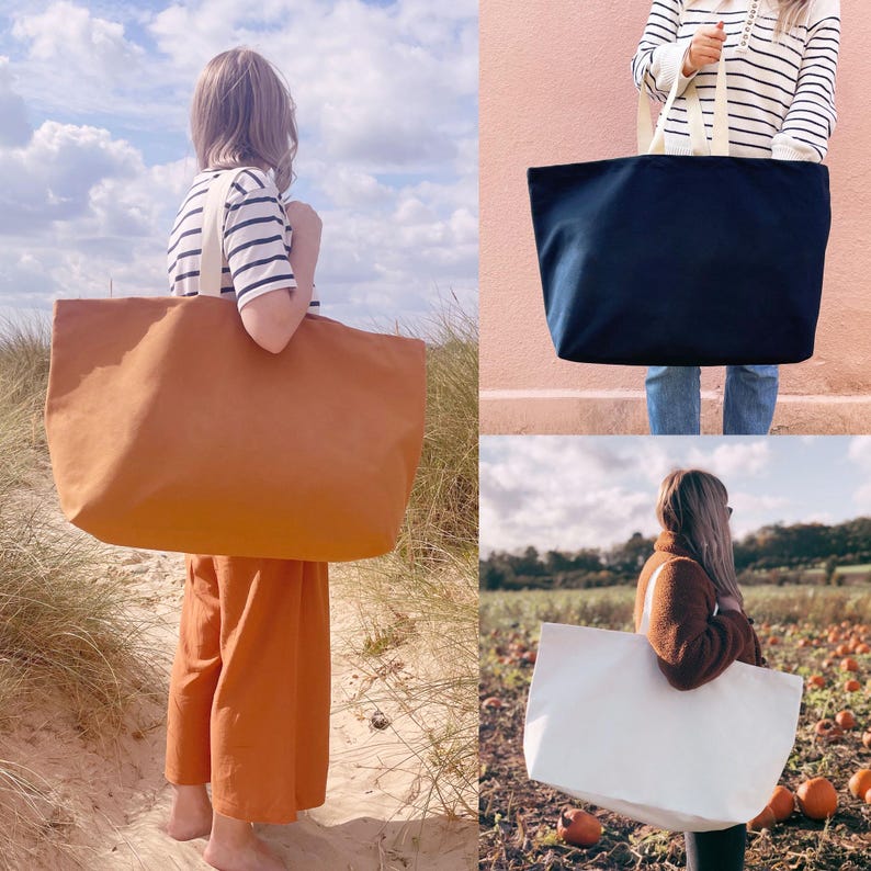 Op de afbeelding: Drie tote bags in verschillende kleuren: bruin, marineblauw en wit. De tassen hebben een eenvoudig ontwerp met twee handvatten en een grote, open bovenkant.