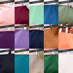 Op de afbeelding: Een kleurenkaart met 15 verschillende kleuren van draagtassen. De kleuren zijn: blush roze, bordeauxrood, zeegroen, oceaanblauw, olijfgroen, pruim, lavendel, middernachtblauw, bruin, perzik, zwart, tropisch blauw, steen, bosgroen en naturel.