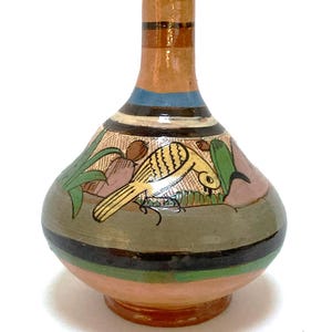 May include: A hand-painted ceramic vase with a bulbous body and a narrow neck. The vase features a yellow bird design with green and brown accents. The base is a light peach color, with black, green, and brown bands around the body.