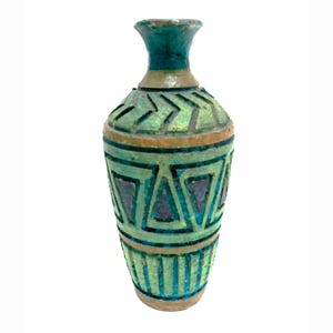 May include: A decorative ceramic vase with a narrow neck and a wide body. The vase features a green and teal geometric pattern with brown accents. The vase is approximately 8 inches tall.