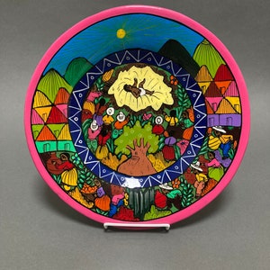 storytelling pottery plate, village scene with baby and tree, bright pink rim, multicolor, hand painted in Mexico