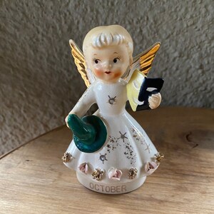 Vintage Halloween angel of the Month - October.  No identifying marks.  Angel holds a mask and witch hat.  Short haired, rosy cheeked angel.