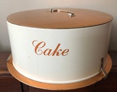 Vintage cake carrier, light weight metal cake carrier with clips at base to secure the top. Copper and cream color. Retro.