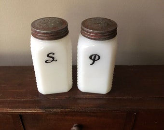 Antique salt and pepper shakers.  “Rehabbed” after paint was nearly worn off.  Newly lettered. 1930, range top set.  Milk glass.  Nice.