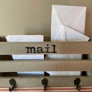 Wood mail holder, wall mount.  Rustic and hand stamped with the word MAIL.  Roomy with hooks for keys.