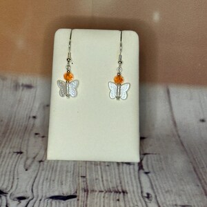 Oranje kristallen en witte vlindervormige hangoorbellen handgemaakte Britse sieraden