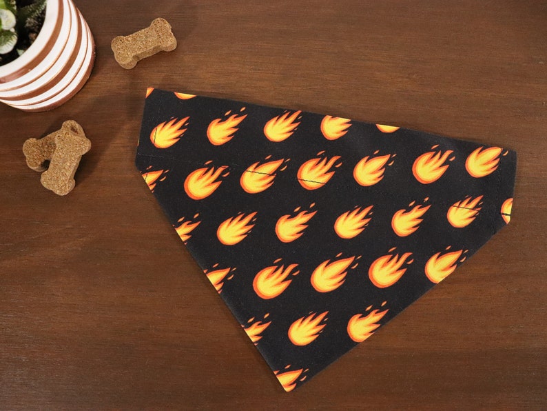 May include: A black dog bandana with a repeating pattern of orange flames.