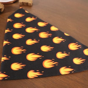 May include: A black dog bandana with a repeating pattern of orange flames.