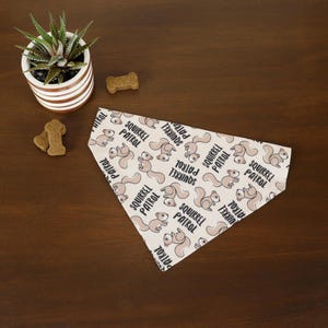 May include: A white dog bandana with a repeating pattern of brown squirrels and the text "Squirrel Patrol".