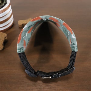 May include: A black dog collar with a green and orange fabric pattern featuring the text "I love turkey".