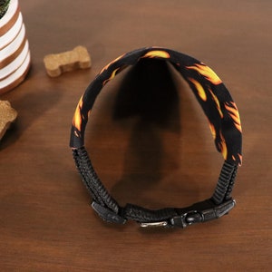 May include: Black dog collar with a flame pattern and a black buckle.