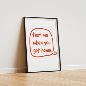 May include: A framed print with a white background and a red speech bubble that says "text me when you get home."