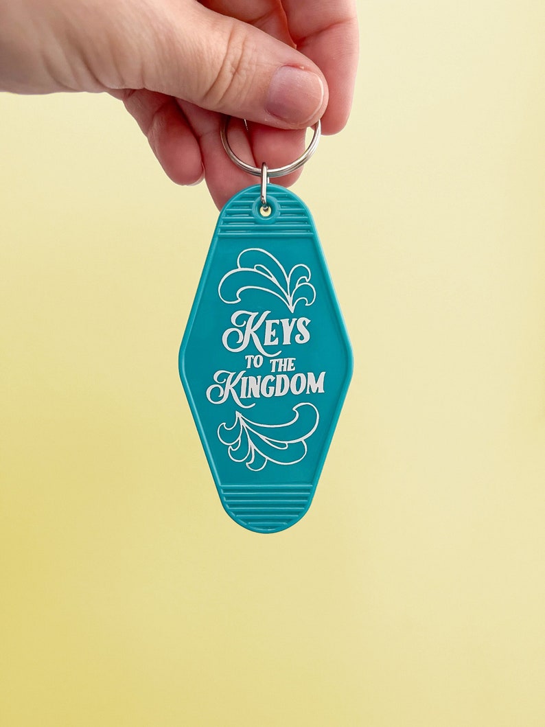 K&ouml;nnte beinhalten: Ein t&uuml;rkisfarbener Motel-Schl&uuml;sselanh&auml;nger mit dem Text "Keys to the Kingdom" in wei&szlig;en Buchstaben. Der Schl&uuml;sselanh&auml;nger ist in Form eines traditionellen Motel-Schl&uuml;ssels gestaltet.