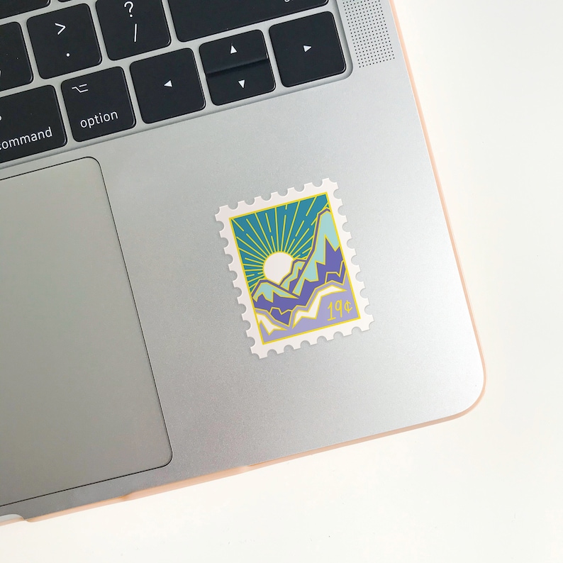 May include: A vintage-style postage stamp sticker with a blue, green, and yellow mountain landscape design. The stamp has a yellow border and says "19&cent;" in the bottom right corner.