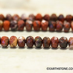 May include: A strand of red, brown, and white jasper beads with a faceted finish. The beads are approximately 8mm in diameter.