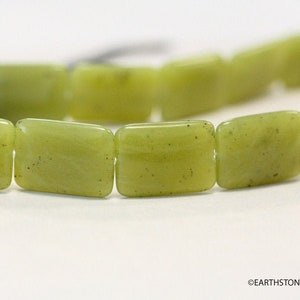 May include: A strand of light green jade rectangular beads. The beads have a slightly mottled appearance.