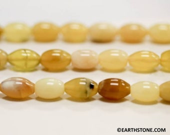 Puede incluir: Una hebra de cuentas de piedras preciosas ovaladas de color amarillo claro y crema. Las cuentas están enhebradas en un hilo transparente y están dispuestas en un patrón repetitivo.