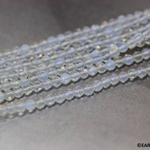 May include: A strand of light blue gemstone beads. The beads are round and have a smooth, polished finish.